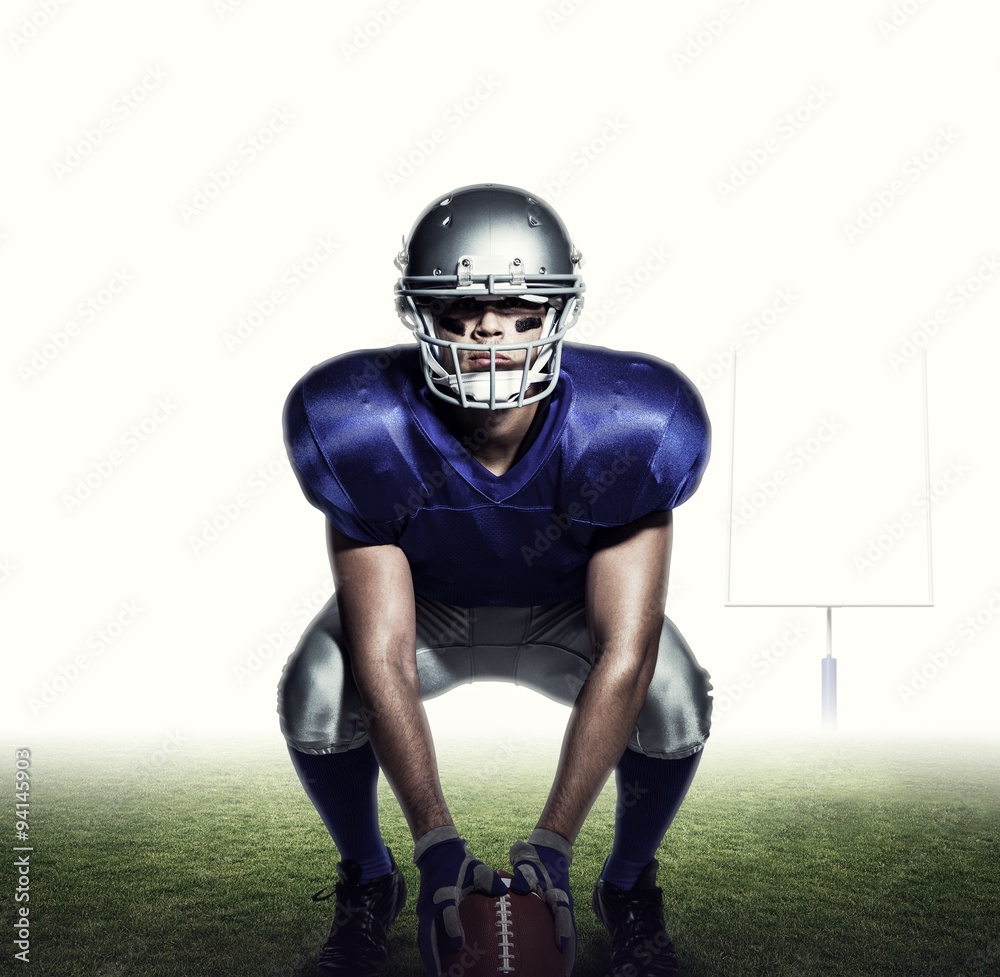 Composite image of american football player with ball crouching