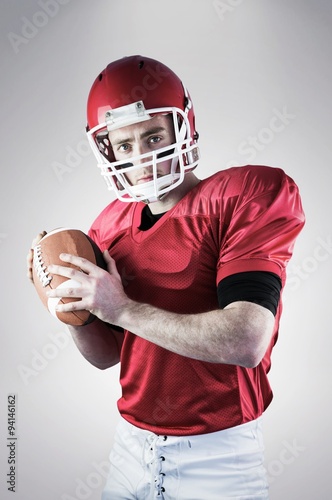 Portrait of american football player holding the ball
