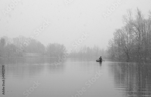 Man in boat on lake, in winter time