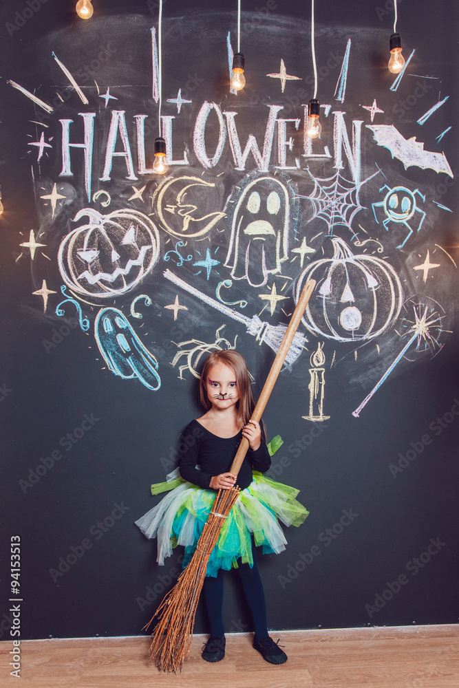 Girl dressed up in Halloween costumes. Posing on the background of the inscription Halloween.