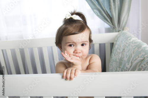 Infant baby resting and playing in his little baby bed photo