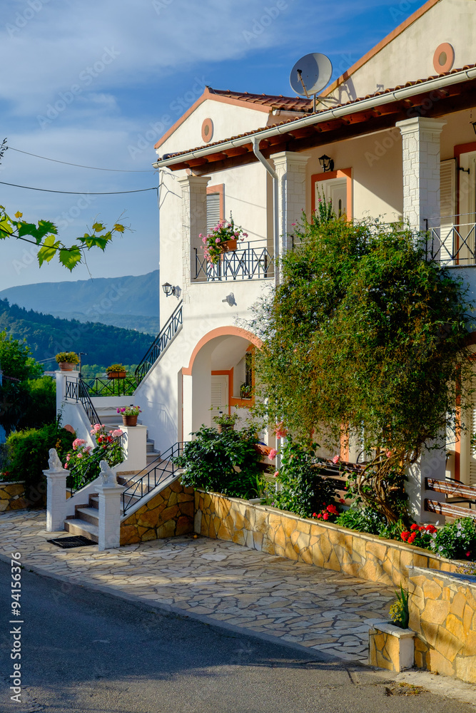 A beautiful greek house up a hill surrounded wirh blooming flowers, Corfu, Greece.