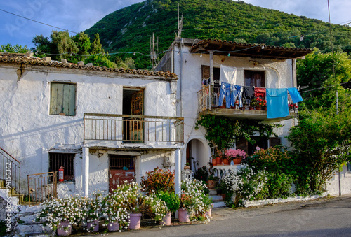 A beautiful greek house up a hill surrounded wirh blooming flowers, Corfu, Greece.