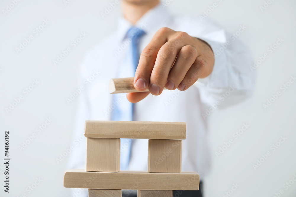 Businessman making tower Businessman making tower
