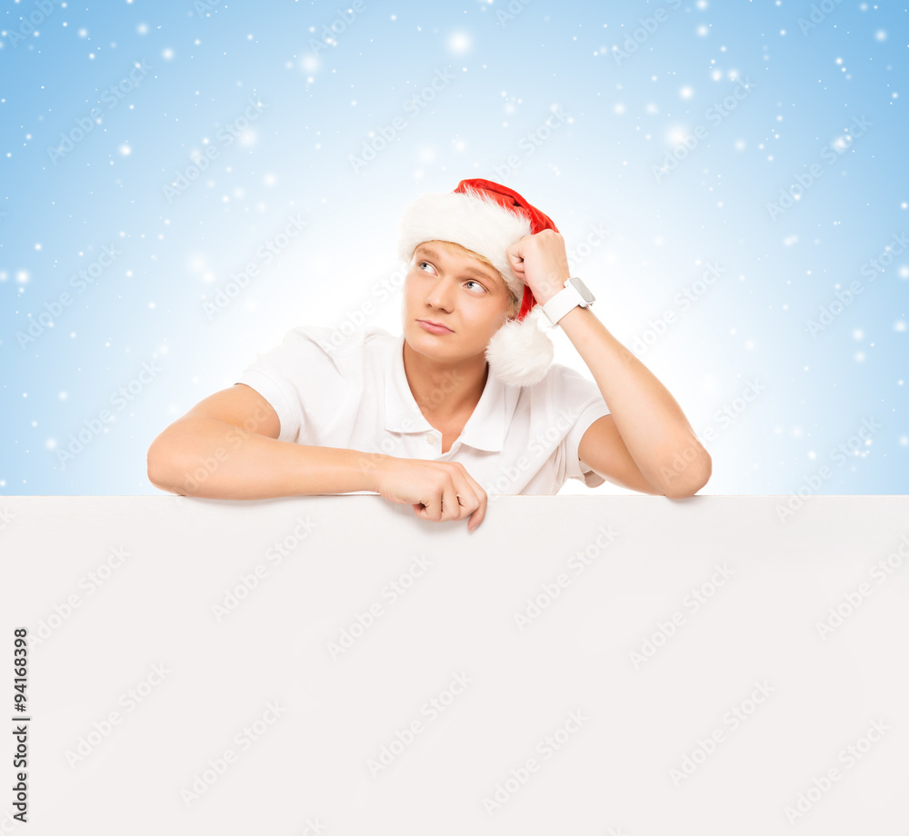 Handsome young man with a blank billboard and Christmas hat over Handsome young man with a blank billboard and Christmas hat over