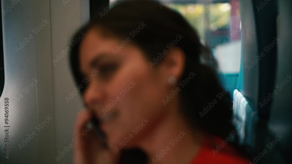 Woman talking on her cell phone inside a train Woman talking on her cell phone inside a train