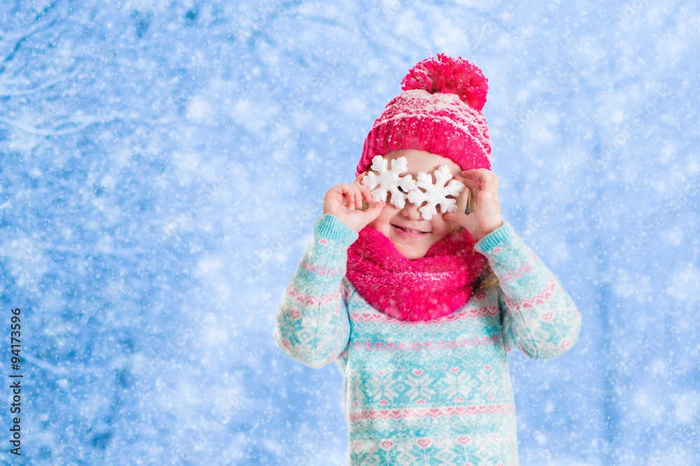 Little girl playing with toy snow flakes in winter park Little girl playing with toy snow flakes in winter park