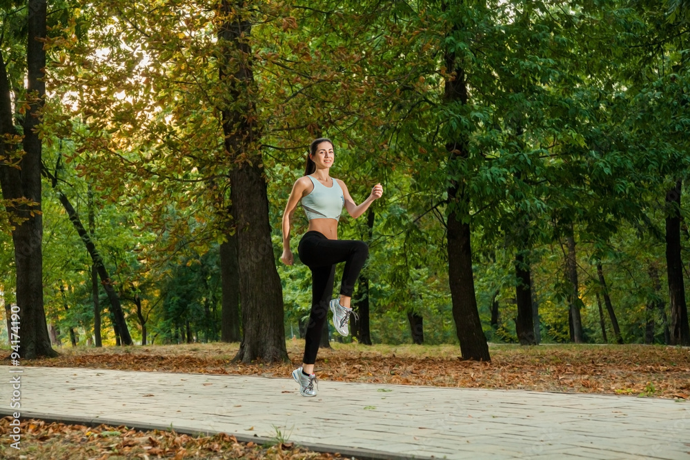 A young beautiful girl is running into the park on cool season a A young beautiful girl is running into the park on cool season a