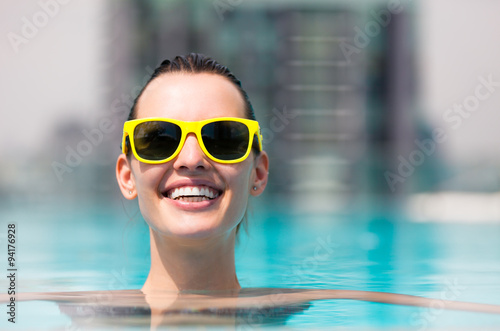 Young happy woman relaxing in a pool.