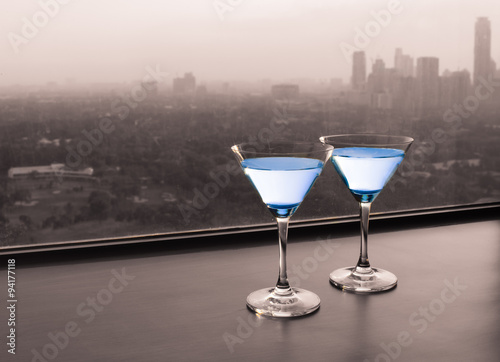 Cocktail glasses with city view.