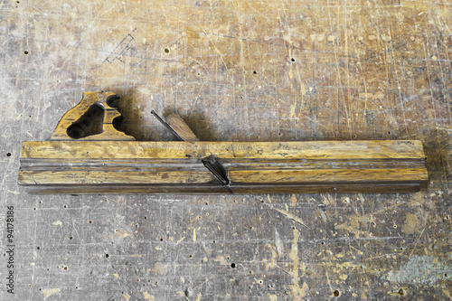 Old carpenter tool planer on vintage wooden background