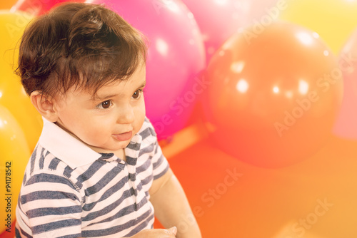 portrait of happy baby boy with yellow ballons