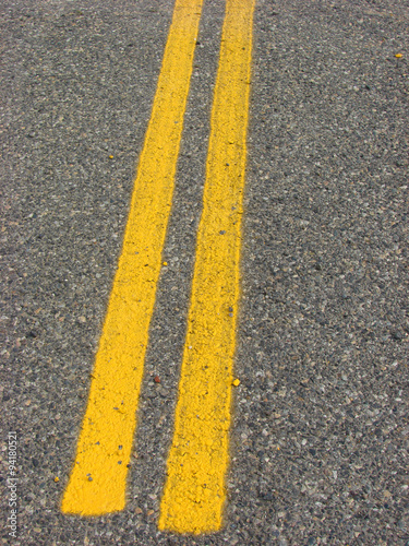 yellow road lines on asphalt road © jdoms