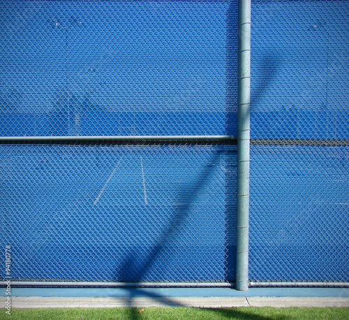 blue fence with tennis courts inside