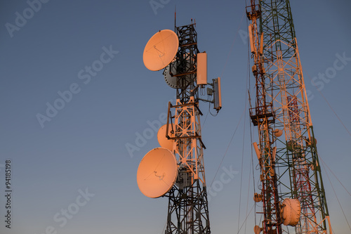 Telecommunications tower at sunrise and blue sky.