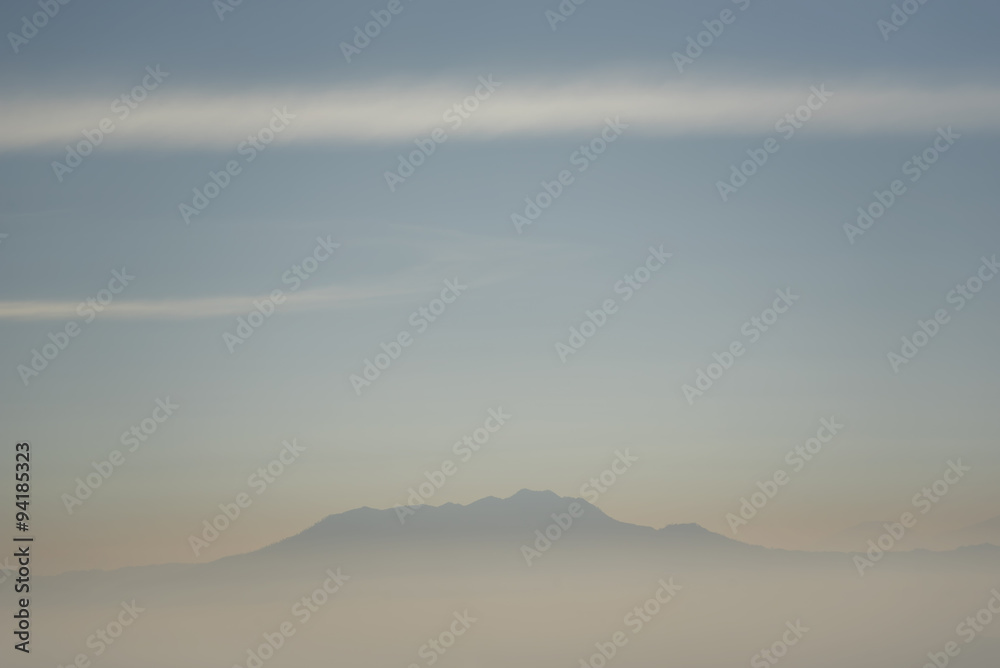 Foggy and volcano mountain during sunrise taken from Pinajagun II view point ,Indonesia.