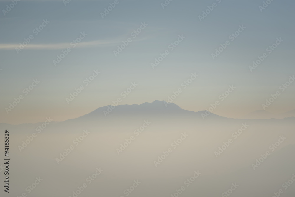 Foggy and volcano mountain during sunrise taken from Pinajagun II view point ,Indonesia.