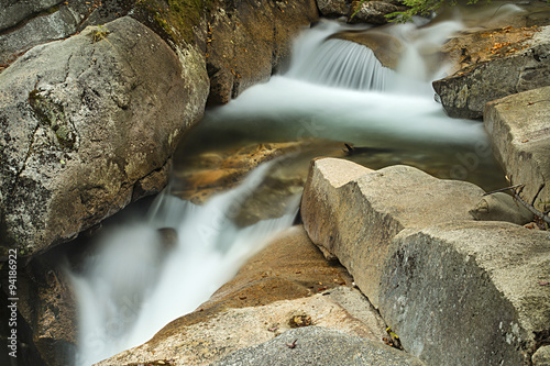 Waterfall cascading over granite rocks near The Basin, New Hamps photo