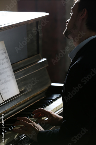 Musician plays piano in dar...