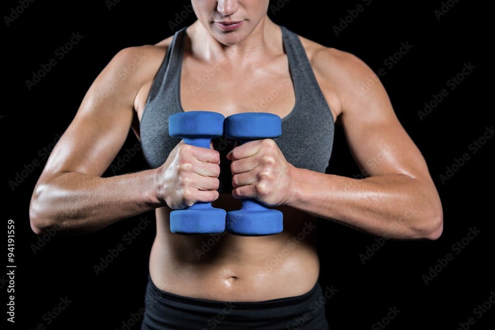 Naklejka premium Muscular woman lifting heavy dumbbells