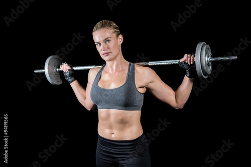 Muscular woman lifting heavy barbell 