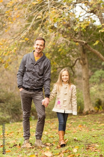 Happy father and daughter walking together in park