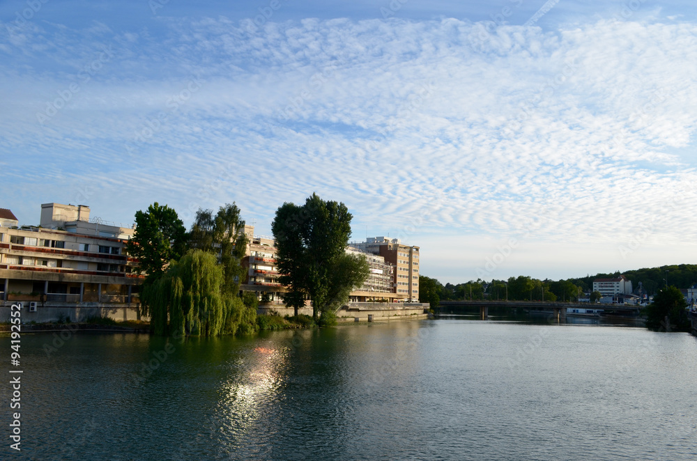 Trees and buildings on shore of river Marne in French city Meaux