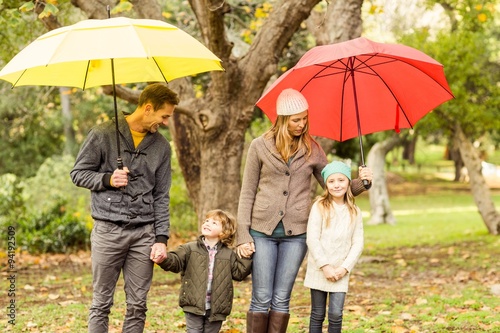 Smiling young family under umbrella