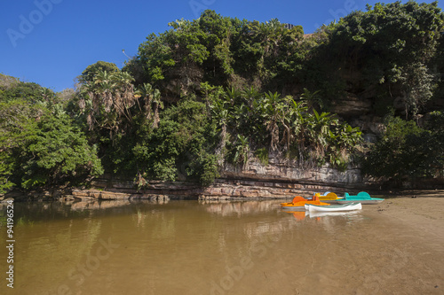 Fototapeta Naklejka Na Ścianę i Meble -  Beach River lagoon canoes along rocky cliff landscape