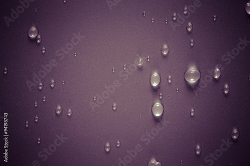 Drops of water on a color background. Purple. Selective focus. T