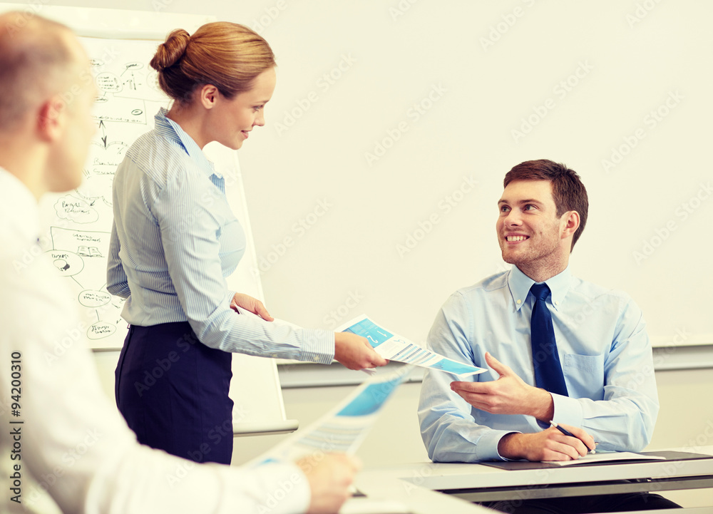 Fototapeta premium smiling woman giving papers to man in office