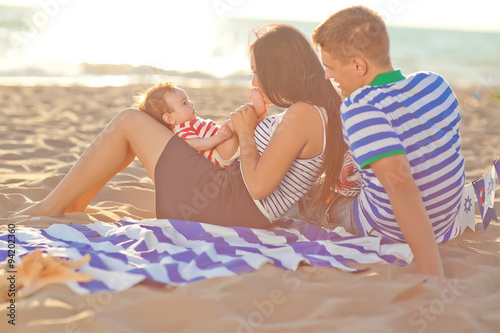 Happy family are resting in the evening time on the beach