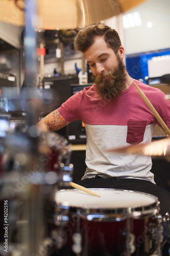 male musician playing cymbals at music store