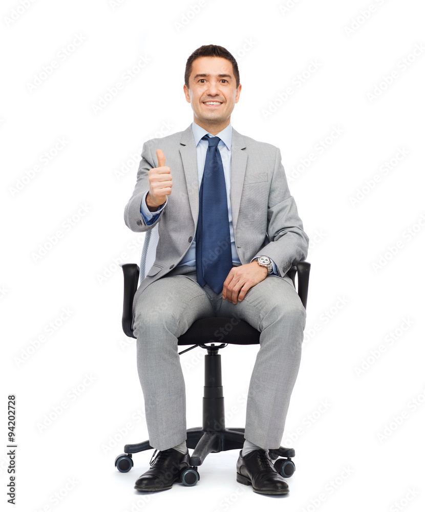 happy businessman sitting in office chair happy businessman sitting in office chair