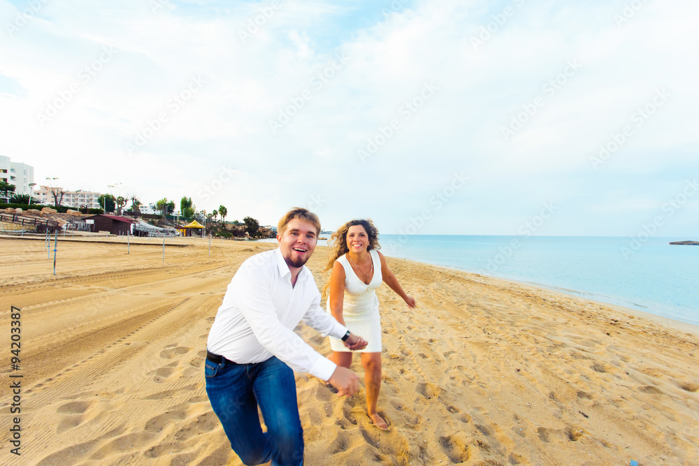 Fototapeta premium happy couple running on the beach