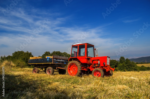 Old red tractor on the agricultural field