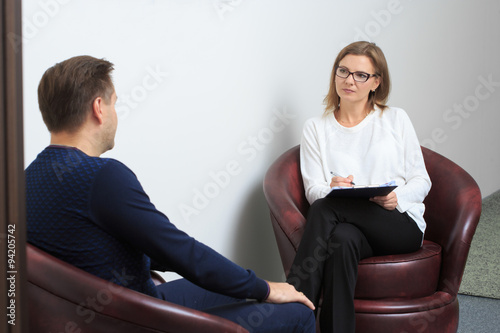 psychologist consulting pensive man during psychological therapy