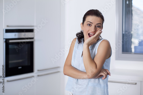 Young woman is sitting in the kitchen