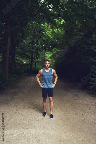 Athletic young man standing waiting in a park