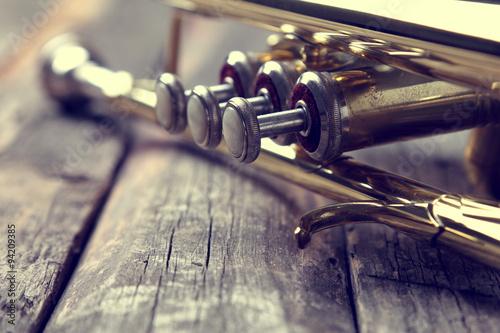 Trumpet on an old wooden table. Vintage style. photo