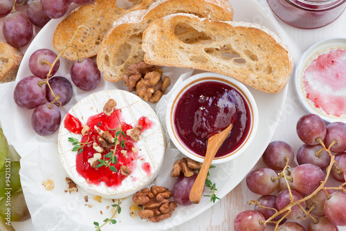 appetizers for wine - camembert with berry jam, toast and fruit