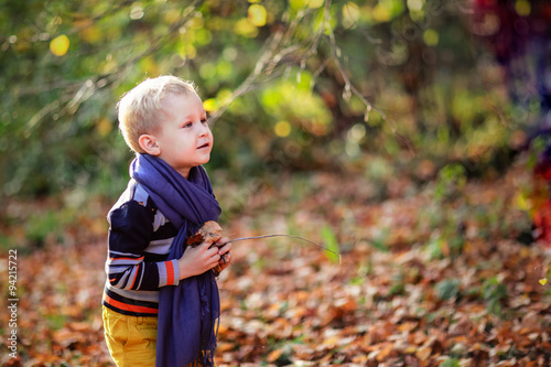 autumn baby boy and his mother throwing yellow leaves