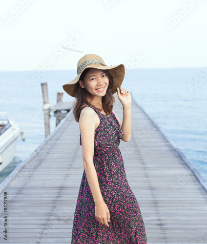 portrait of beautiful young woman wearing wide straw hat and lon © stockphoto mania