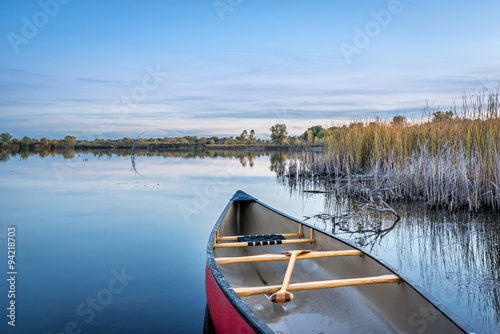 dusk over calm lake with a canoe