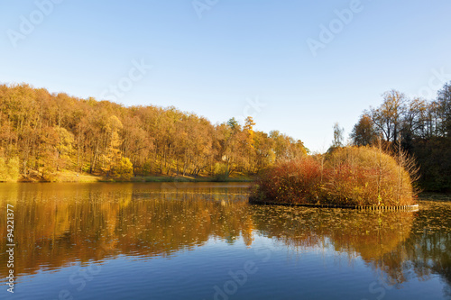 Autumn landscape on a sunny day with the pond and the small island in Tsaritsyno, Moscow, Russia