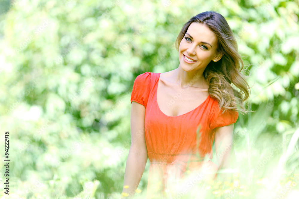 young woman in red dress sitting on grass young woman in red dress sitting on grass