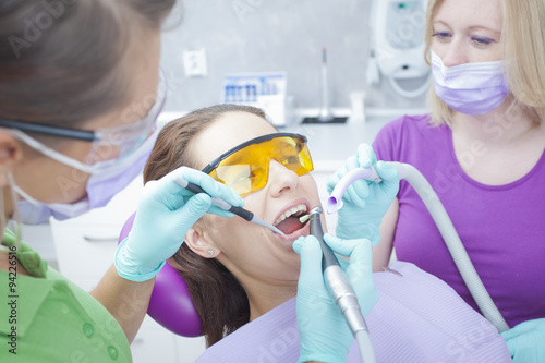 Female dentist and her female assistant working on teeth of wome