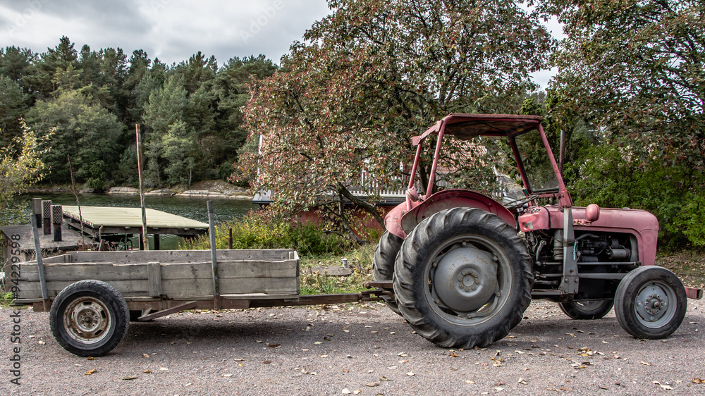 Retro red old tractor with a chariot Retro red old tractor with a chariot