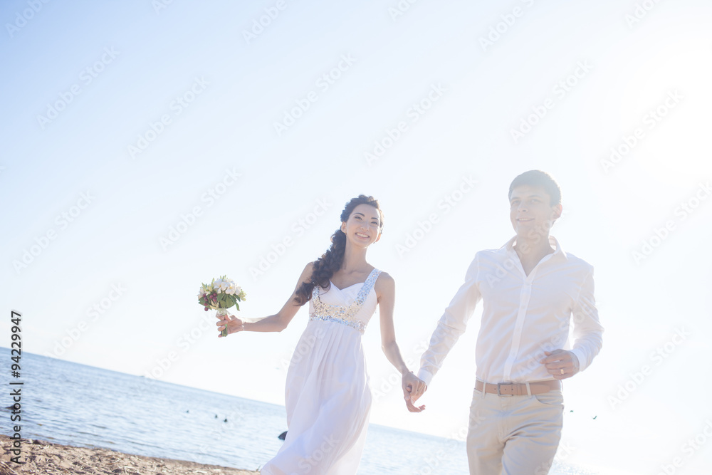 Just married happy couple running on a sandy beach Just married happy couple running on a sandy beach