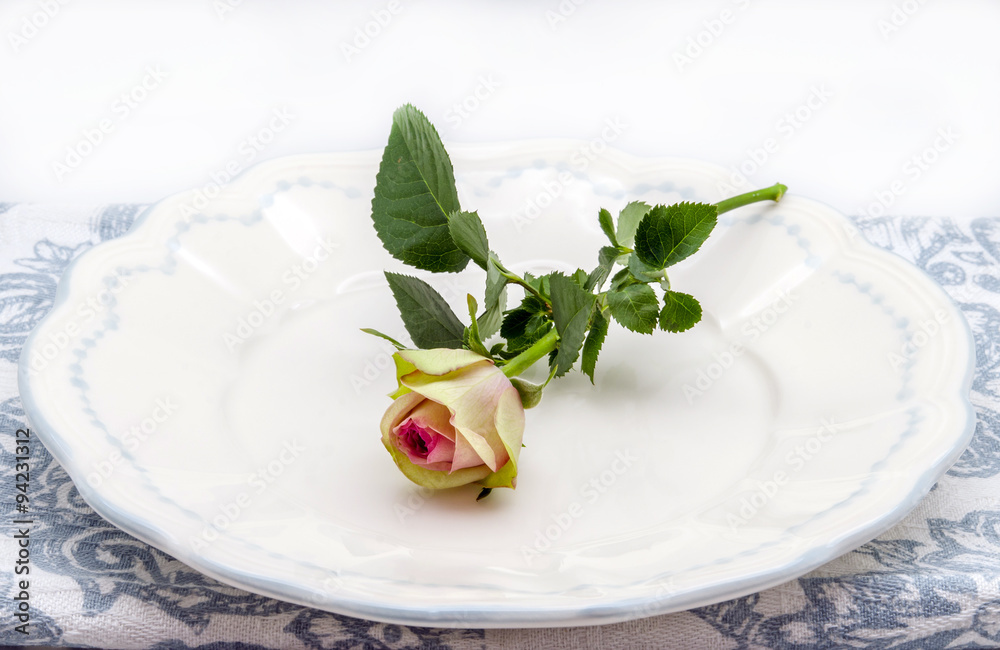 Decoración de mesa con plato y una rosa